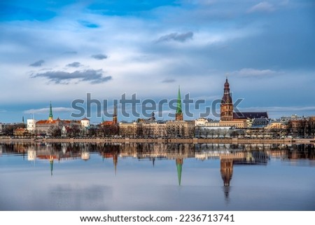 Riga city silhouette during the day. Riga towers, blue sky and clouds in the background. Photographed from Pārdaugava from the other bank of the river Daugava. Panorama of Riga. The Capital of Latvia.