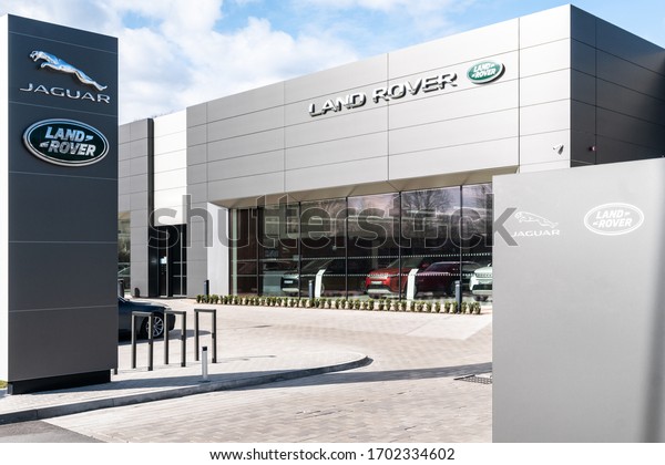 Riga, Latvia 10 April 2020 Land Rover\
brand logo on bright blue sky background located on its dealer\
Entrance in showroom of dealership office building.\
