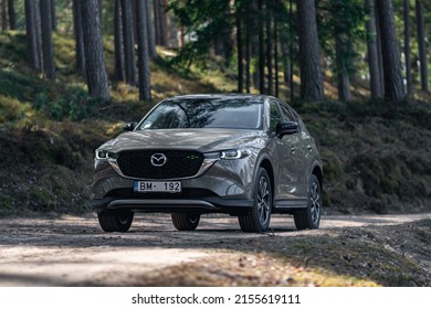 Riga, Latvia 12 May 2022, Mazda CX-5  Redesigned Crossover SUV. Driving countryside in forest. Front view.