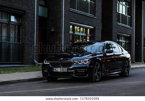 Riga, Latvia 12 September\
2018, BMW 750 M Sixth generation G11 stands at parking slot by\
modern house 