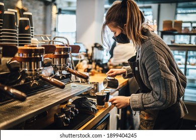 Riga, Latvia 2021, 21. January Women Barista In An Apron Making Coffee In A Coffee Shop Wearing Face Masks Against COVID-19