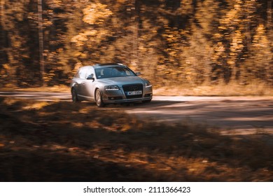 Riga, Latvia 21 October 2021: Front view of Audi A6 3.0 TDI Quattro in the sunny autumn forest, auto in fast motion with a blurred background.