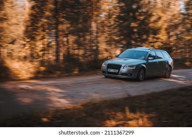 Riga, Latvia 21 October 2021: Front view of Audi A6 3.0 TDI Quattro in the sunny autumn forest, auto in fast motion with a blurred background.