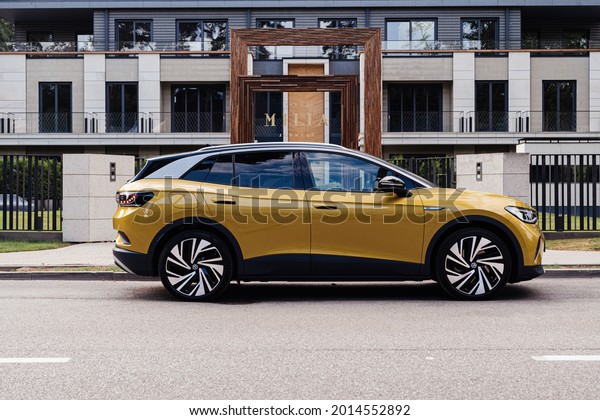 Riga, Latvia 26 July 2021, Volkswagen ID.4 is an\
electric crossover SUV is positioned by Volkswagen as a\
high-volume, mass-market electric vehicle.\
Stands on parking lot\
by modern luxury  house 