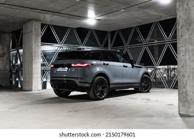 Riga Latvia 27 April 2022, Range Rover Evoque Plug-in Hybrid Brand New Model. Stand On Parking Lot In Modern Office Buildings At Night Time, Led Light On. Rear Side View.