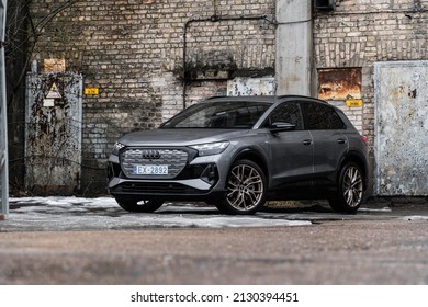 Riga, Latvia 28 February 2022 The Audi Q4 e-tron Sportback is a battery electric compact luxury crossover SUV produced by Audi. Stands on parking lot, led light on. Industrial background.