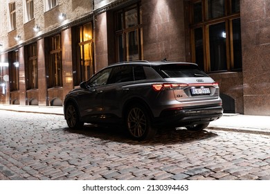 Riga, Latvia 28 February 2022 The Audi Q4 e-tron Sportback is a battery electric compact luxury crossover SUV produced by Audi. Stands on parking lot  at night time, led light on. 