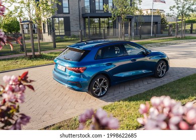 Riga, Latvia 28 June 2021 Audi A3 Sportback Fourth generation (8Y) Stands on parking lot by modern private house summer time mood. Rear and side view. Flowers.