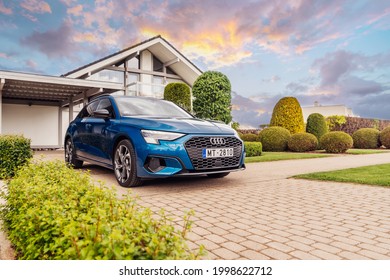Riga, Latvia 28 June 2021 Audi A3 Sportback Fourth generation (8Y) Stands on parking lot by modern private house with amazing sunset mood. Front and side view. 