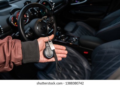 Riga, Latvia 4 May 2019 Mini Keyring In Hand. Man Holding Mini Cooper Keys With Key Chain Front Of Mini Interior. 