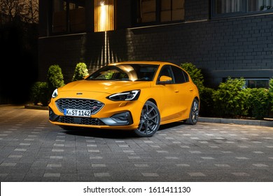 Riga, Latvia 8 January 2020 Ford announced the fourth-generation yellow Focus ST for the European market. Stands in Parking slot at night time. Front view. Background modern house.