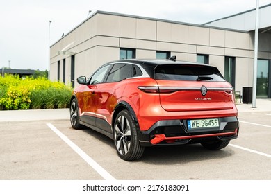 Riga, Latvia 8 July 2022, Renault Megane E-Tech Electric Is A Battery Electric-powered Small Family Car. Business Centre Modern Buildings. Stands On Parking Lot At Sunset Light Mood.