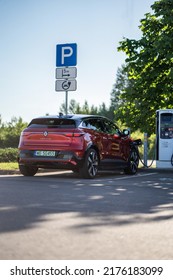 Riga, Latvia 8 July 2022, Renault Megane E-Tech Electric Is A Battery Electric-powered Small Family Car. Charging Station, Charging The Car On Parking Lot. Landscape View Tree.