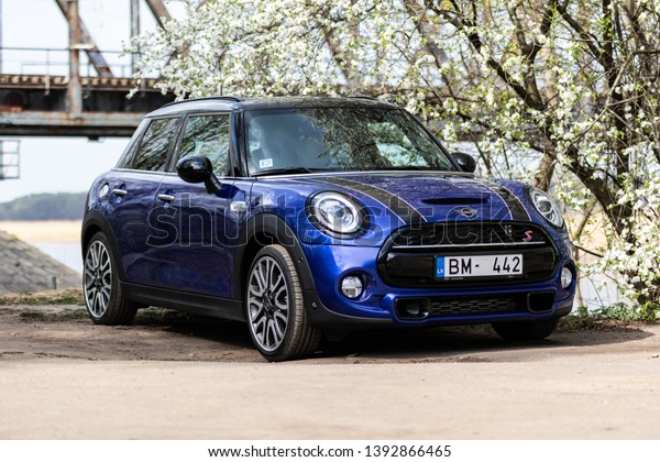 Riga, Latvia 8 May 2019, New Mini Cooper S John\
Cooper Works model year 2019,  Stand in parking by flower tree with\
lights on.
