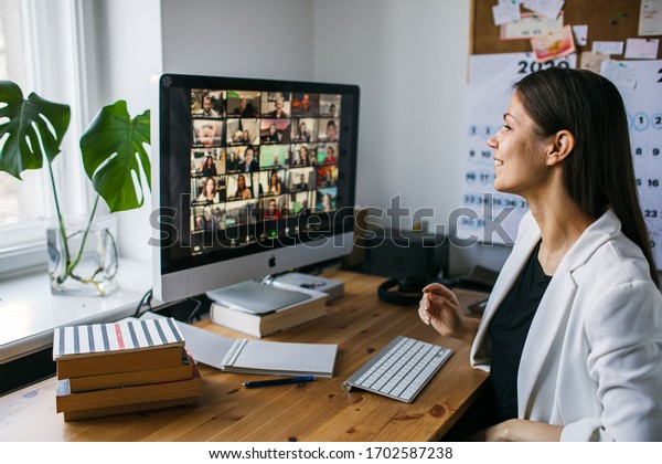 Riga, Latvia - April 04 2020: Beautiful young\
woman having Zoom video conference call via computer. Zoom Call\
Meeting. Home office. Stay at home and work from home concept\
during Coronavirus\
pandemic