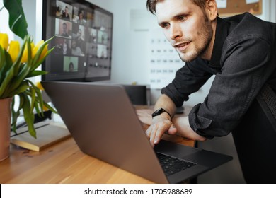 Riga, Latvia - April 09 2020: Smiling Man Having Zoom Video Call Via Laptop In The Home Office. Remote Conference Meeting With Team For Work. Online Office Stay At Home And Work From Home Concept