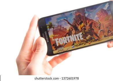 Riga, Latvia - April 15, 2019:  Hands Holding Samsung Mobile Phone With Fortnite Mobile Game Loading Screen