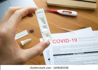 Riga, Latvia - April 8 2020: Coronavirus antibody home test kit. COVID-19 Antigen test cassette for coronavirus. Man holding a rapid testing kits. At-home finger-prick coronavirus test