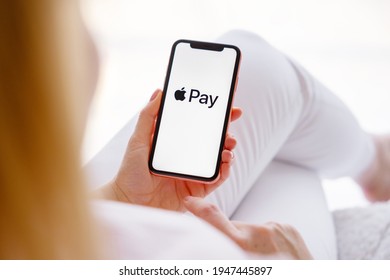 Riga, Latvia - March 26, 2021: Woman Holding Phone With Apple Pay Logo On The Screen