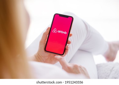 Riga, Latvia - March 26, 2021: Woman Holding Mobile Phone With Airbnb Logo On The Screen