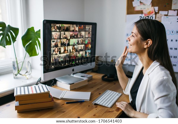 Riga, Latvia\
- March 28 2020: Young woman having video Zoom call via computer in\
the home office. Remote teem meeting Stay at home and work from\
home concept. Manage Online\
office