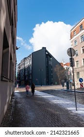 Riga, Latvia. March 30, 2022. View From The Street With Two Women Walking Away From The Camera