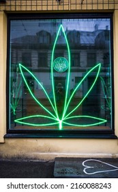 Riga, Latvia, May 21, 2022 A Large Neon Marijuana Leaf Adorns A Window Of A Coffee Shop.