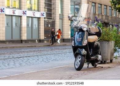 Riga, Latvia - October 8, 2020: Black Classic Vespa Scooter Parked On A Pedestrian Sidewalk In The City Center Street