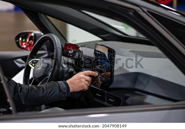 Riga, Latvia, Sep 24, 2021: inside view of\
the Volkswagen (VW) ID4 electric car, driver setting up satnav\
using touchscreen