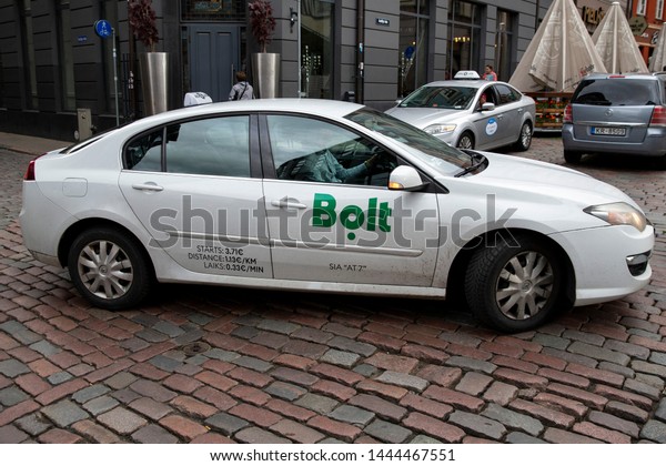Riga/Latvia July 5, 2019\
Modern city taxi cab car\
with Bolt online internet taxi transportation service side markings\
on street at Riga city\
center
