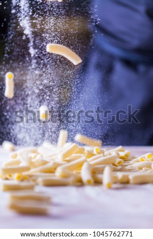 Rigatoni Penne Lisce Tortiglioni Doppia Rigatura. Home made rigatoni pasta on the table with flour. Fresh pasta with wheat flour. Penne rigate Fresca pasta. Sprinkling wheat flour over home made pasta
