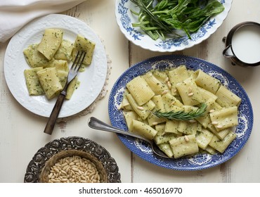 Rigatoni With Pesto Sauce. Overhead View Of Dinner Table With Blue China Platter, Fresh Herbs, Creamer, Antique Fork And Silver Serving Spoon. 