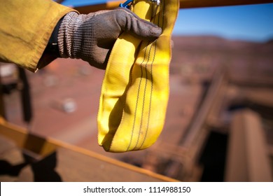 Rigger Inspector High Risk Worker Hand Wearing Heavy Duty Glove Holding Inspecting A Yellow Three Lifting Sling Prior Used In Sydney City Construction Building Site, Australia 
