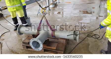 riggers move the pipe using two chain blocks