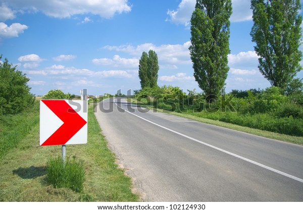 Right\
arrow direction sign by the curvy road at sunny\
day