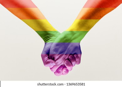 Right To Choose Your Own Way. Loseup Shot Of A Gay Couple Holding Hands, Patterned As The Rainbow Flag Isolated On White Studio Background. Concept Of LGBT, Activism, Community And Freedom.