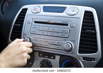 The Right Hand Of An Adult Woman Adjusting The Sound Volume In The Car Stereo