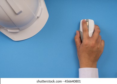 Right Hand Click Mouse Computer And Safety Helmet, Blue Background, Contract Engineer Concept.