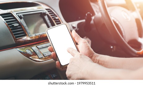 Right Hand Of A Man Holding Smartphone,white Screen,left Hand Index Finger Pointing To A Screen Protruding At Car Stereo,concept Is A Connection Between New And Old Technology Through Smartphone App.