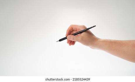 The Right Hand Of A Man Holds A Pen For Calligraphy And Writing, Gesture Writes