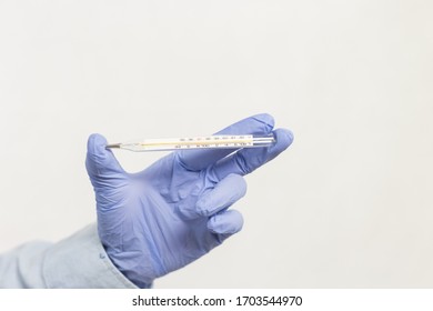 The Right Hand Of A Physician Is Holding Mercury To Measure Fever. The Viral Outbreak Surveillance Infective
Or Infectious Concept With White Background