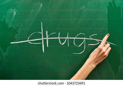 Right Hand Of A Teenage Girl Writing Drug Protest On The Green School Board Background