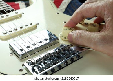 Right Hand Is Tuning The Volume Knob Of Vintage Ivory Color Electric Guitar During Fixing And Changing The Guitar Strings After The Concert Performance