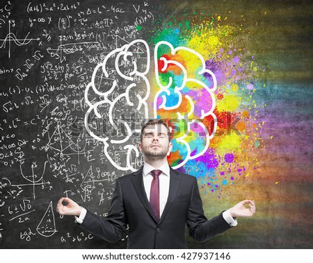 Right and left hemispheres, creative and analytical thinking concept with businessman meditating against chalkboard with sketch