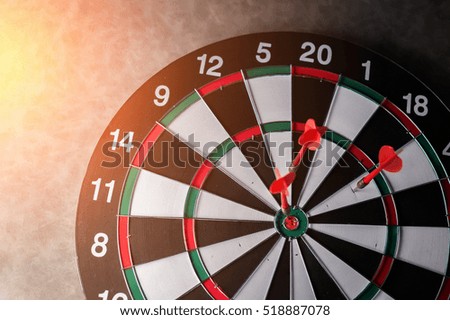 Right on target concept using dart in the bullseye on dartboard business success concept