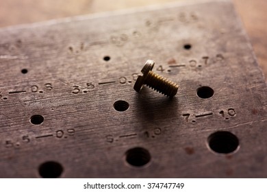 Right Size. Finding The Correct Size Or Combination. Fitting. Old Brass Screw Inserted In A Screw Diameter Gauge. Shallow Depth Of Field.