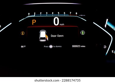 Right sliding rear door open warning on instrument panel or dashboard control of modern minivan car, low milage only 23 miles glowing illuminated LED indicator display.  Driving safely assistant tech