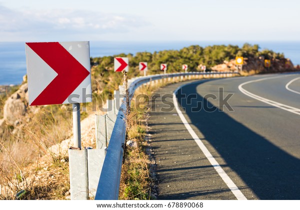 Right Turn Sign: Road signs warn of a sharp turn on\
a narrow road