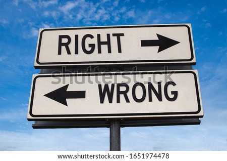 Right vs wrong. White two street signs with arrow on metal pole with word. Directional road. Crossroads Road Sign, Two Arrow. Blue sky background. Two way road sign with text.