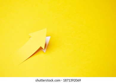 Right-up arrow cutted from solid sheet of yellow paper and curved up of one side with white paper underlay showing growth of stock market or up direction - Shutterstock ID 1871392069